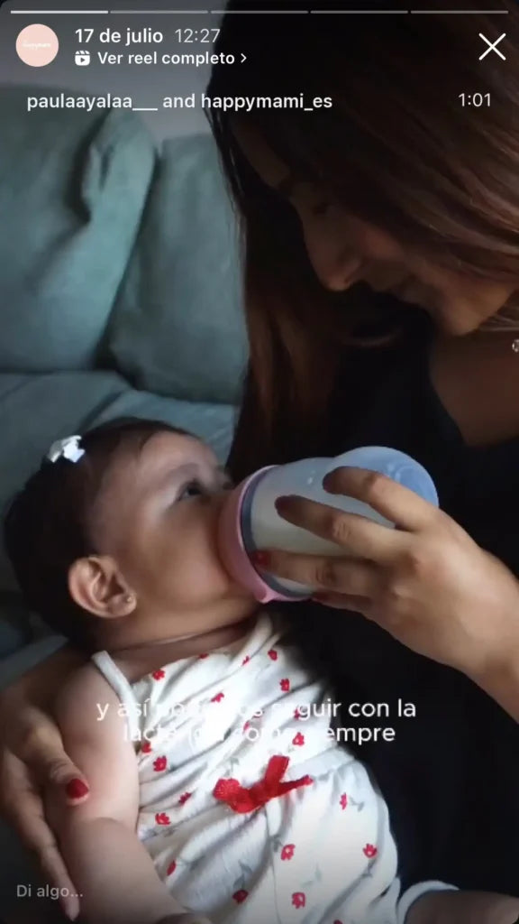 Madre dando el biberón Happymami a un bebé recostado en sus brazos