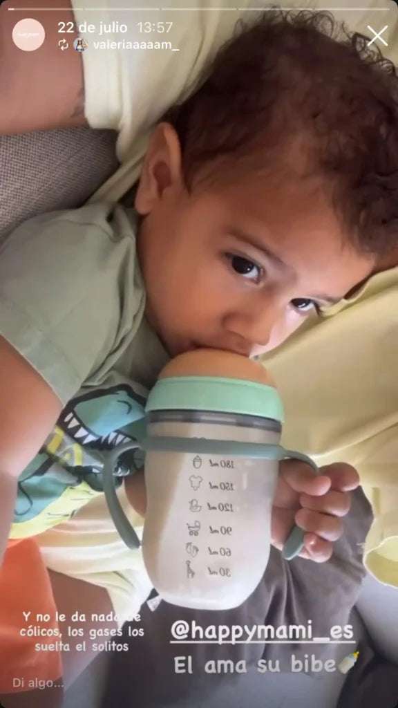 Bebé bebiendo de un biberón Happymami menta con asas y marcas de mililitros