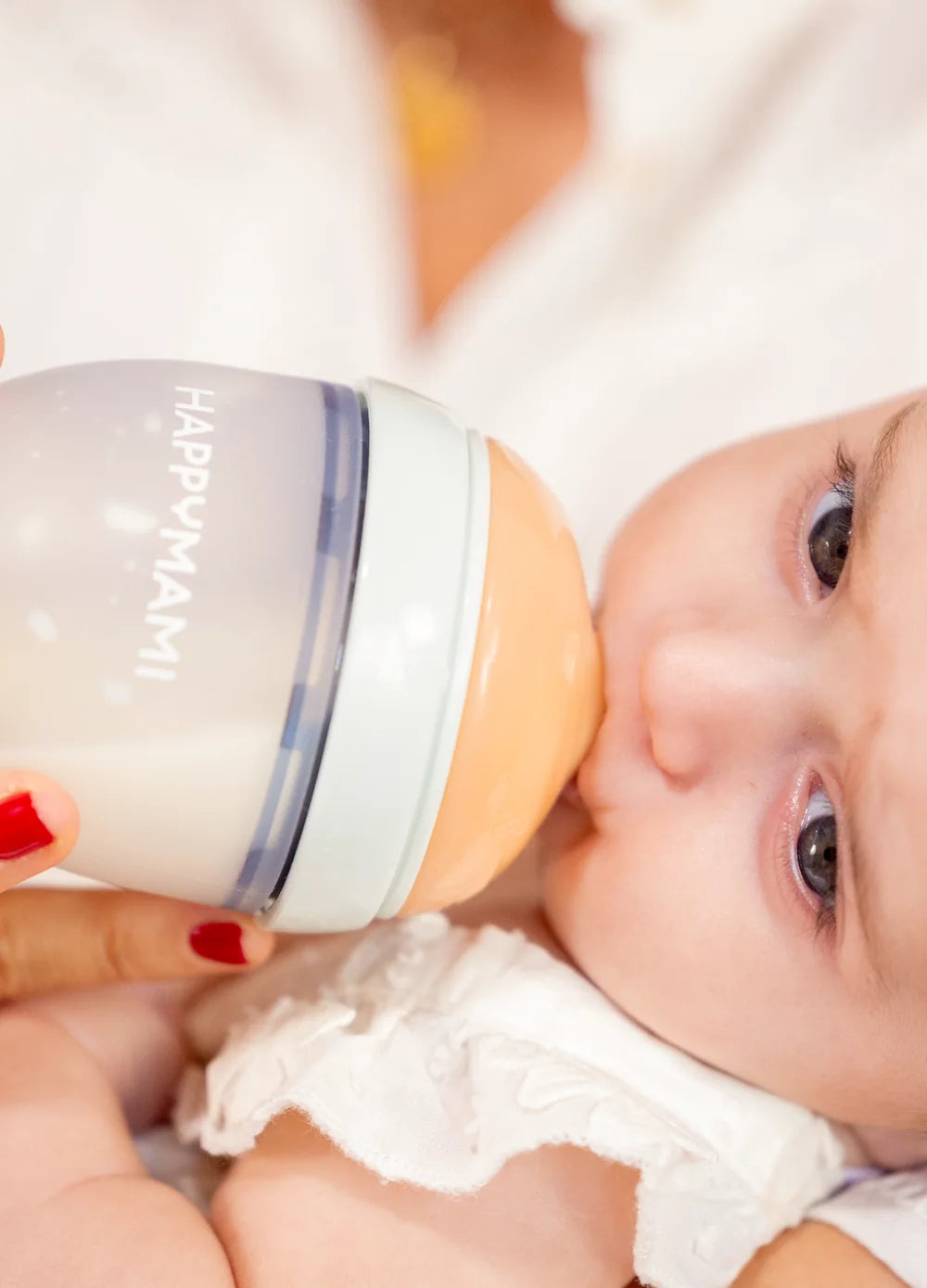 Baby drinking from a Happymami bottle